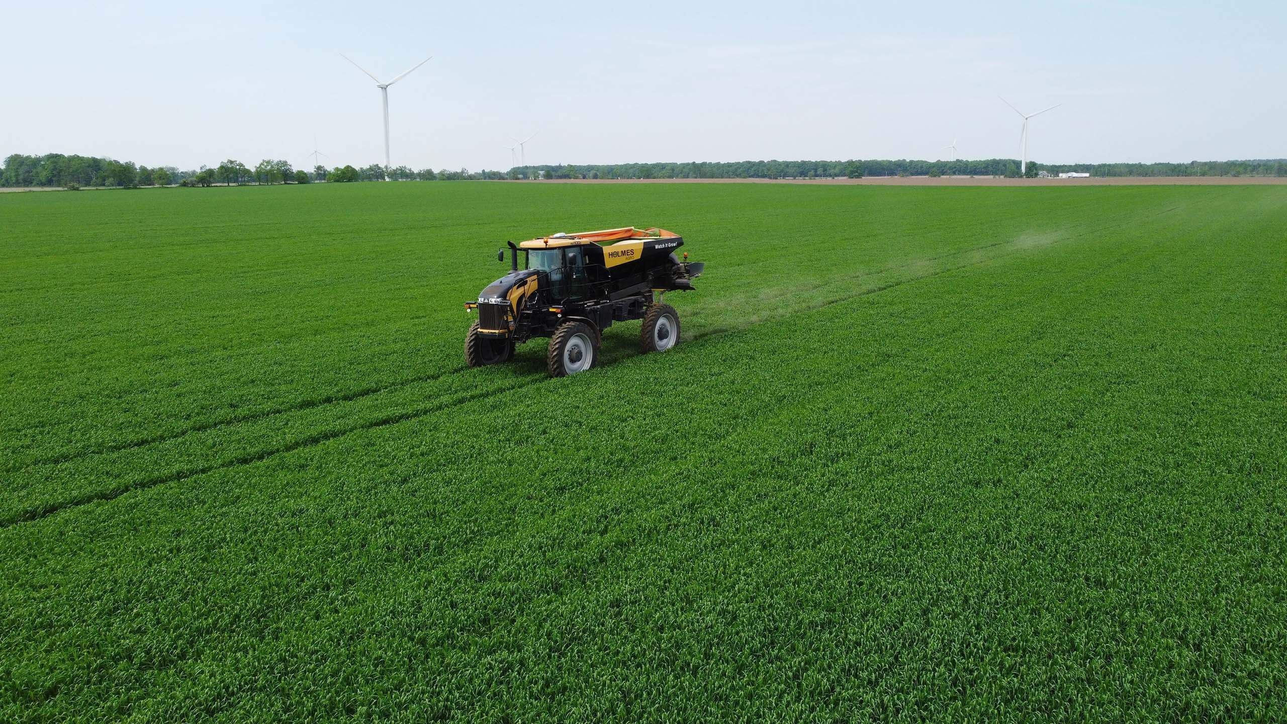 Holmes Agro equipment on crop with blue sky in the background